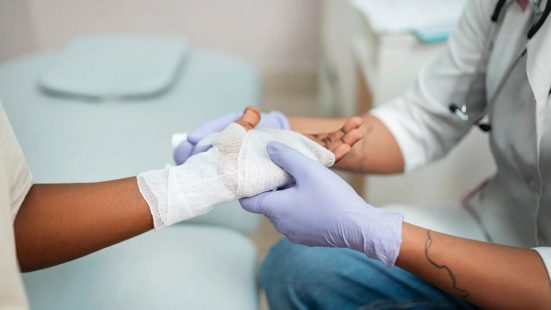 Profesional de la salud brindando atención médica vendando mano de paciente en Clínica La Virgen de Guadalupe