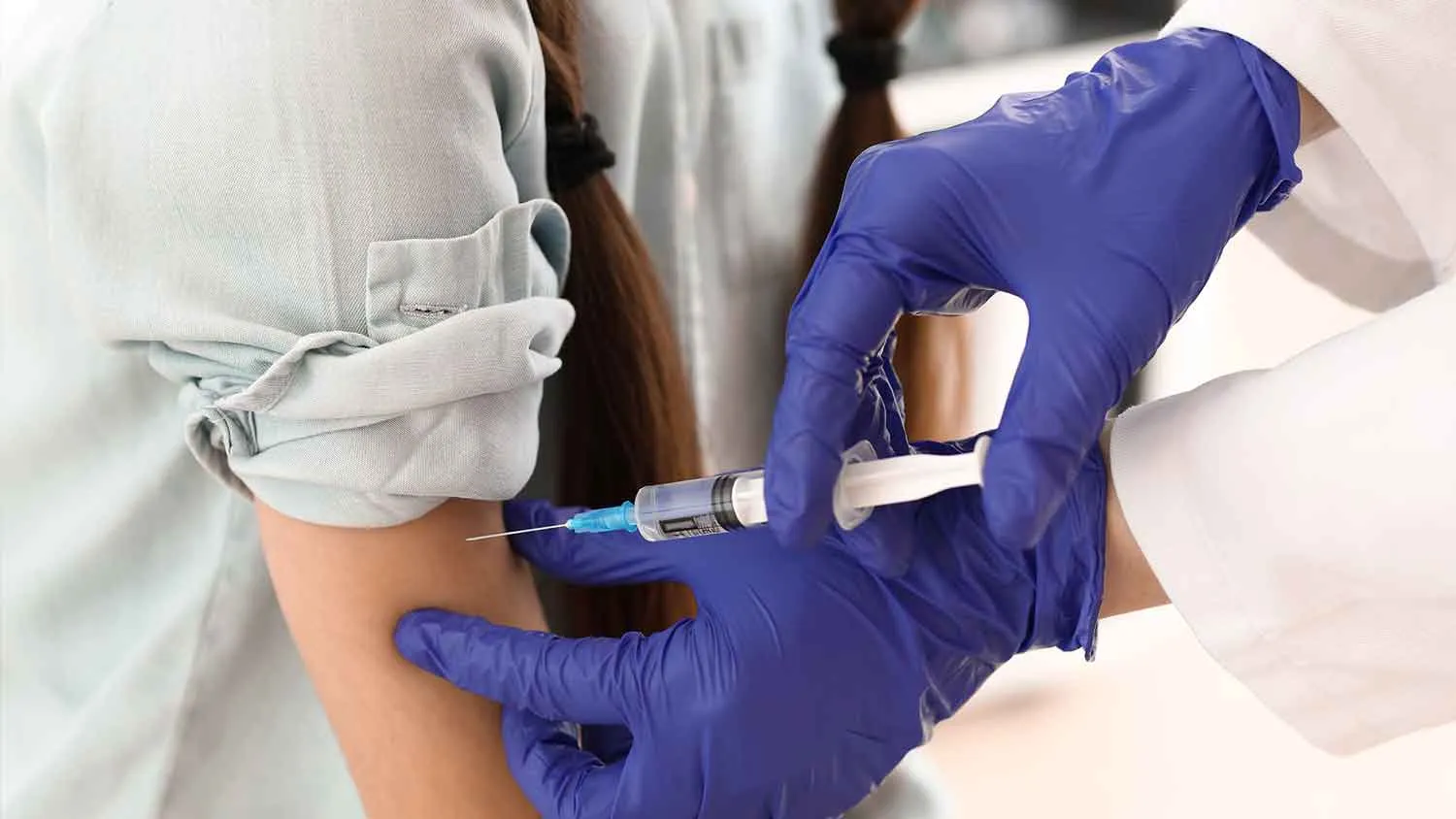 Profesional de la salud aplicando Inyección de vacuna para un paciente en Clínica La Virgen de Guadalupe.